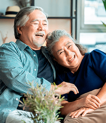 Casal de idosos sentados juntos e felizes. Programa de Assistência ao Idoso oferece atendimento integral aos idosos com equipes formadas por geriatras, fisioterapeutas, nutricionistas, assistentes sociais, terapeutas ocupacionais e fonoaudiólogos.